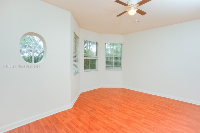 unfurnished room with plenty of natural light, ceiling fan, and hardwood / wood-style flooring