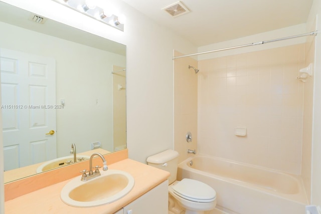 full bathroom featuring tiled shower / bath combo, toilet, and vanity