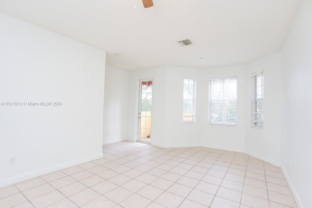 tiled spare room featuring ceiling fan