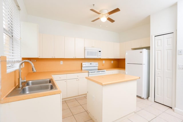 kitchen with ceiling fan, a kitchen island, light tile patterned floors, sink, and white appliances