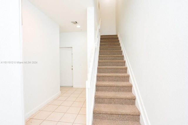 stairway with tile patterned flooring