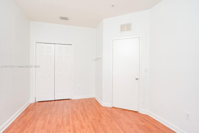 unfurnished bedroom featuring a closet and hardwood / wood-style floors