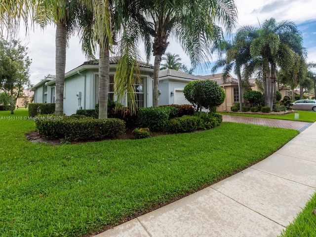 view of side of property featuring a garage and a yard