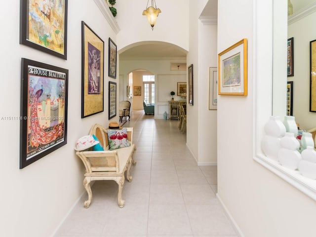 hall with crown molding and light tile patterned flooring