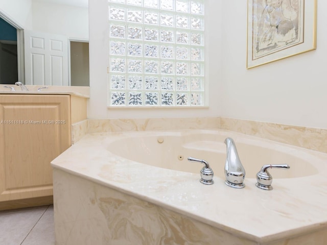 bathroom with a tub to relax in, tile patterned flooring, and vanity