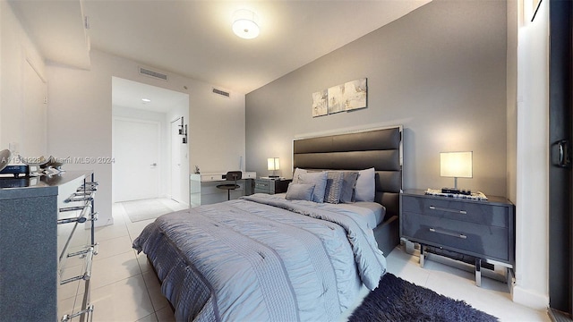 bedroom featuring vaulted ceiling and light tile patterned floors