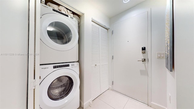 laundry area with stacked washer and clothes dryer and light tile patterned floors