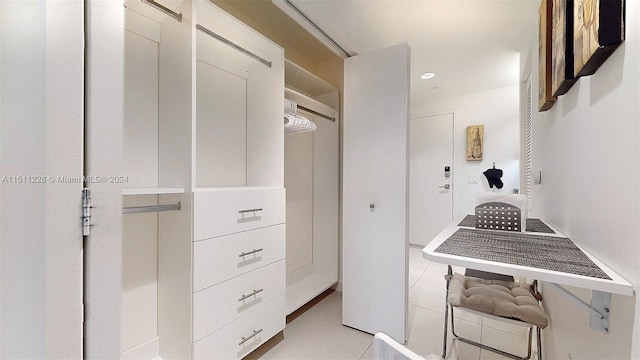 spacious closet featuring elevator and light tile patterned floors