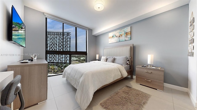 tiled bedroom with multiple windows and a wall of windows