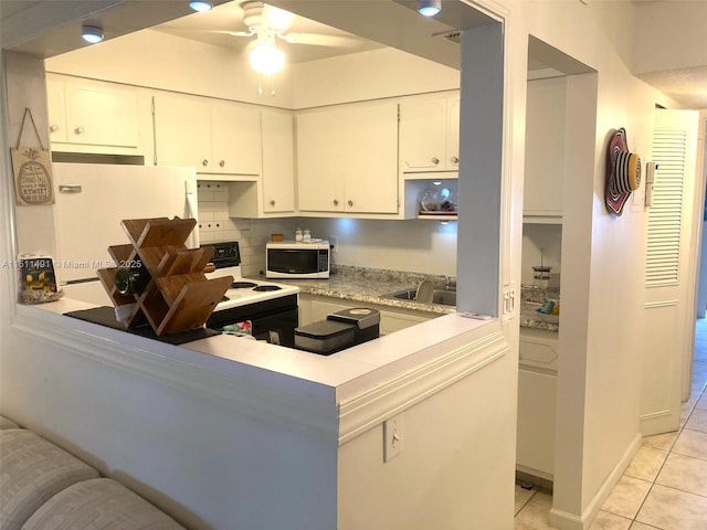 kitchen with light tile patterned floors, ceiling fan, white appliances, white cabinets, and sink