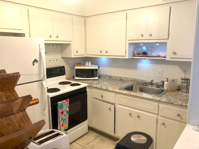 kitchen with light tile patterned floors, white cabinetry, tasteful backsplash, white appliances, and sink