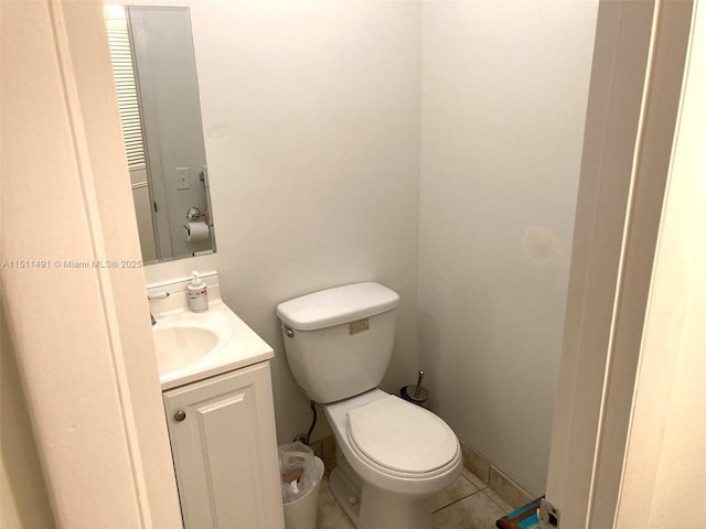 bathroom with toilet, vanity, and tile patterned flooring