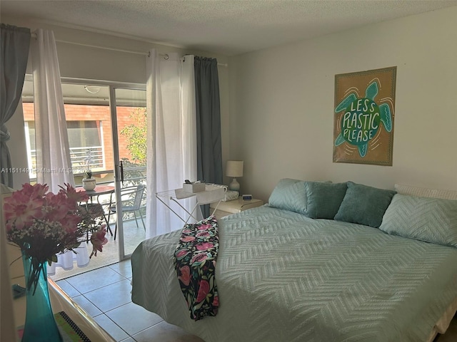 bedroom featuring tile patterned flooring, access to exterior, and a textured ceiling