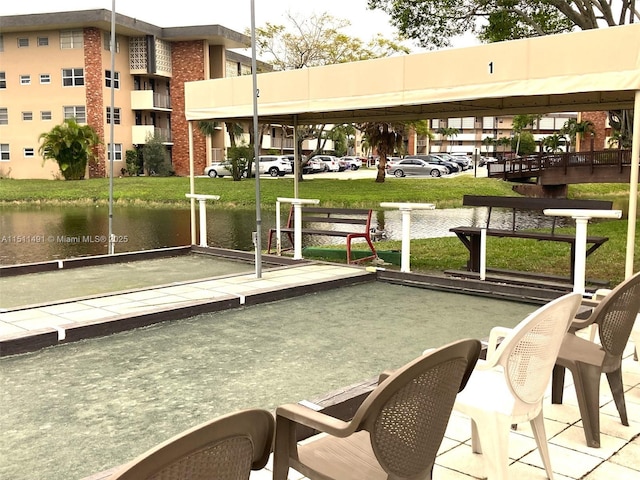 view of dock with a water view and a yard