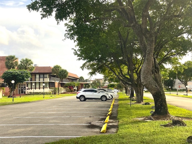 view of parking / parking lot with a lawn