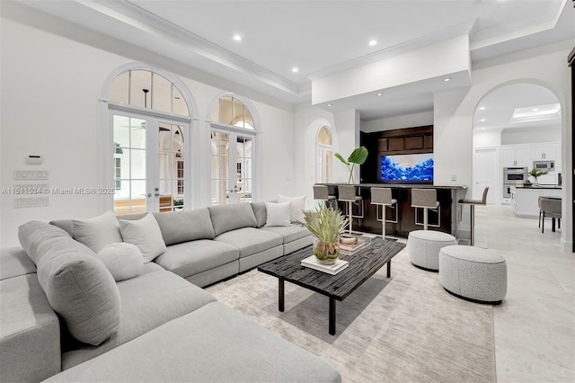 living room with a raised ceiling and french doors