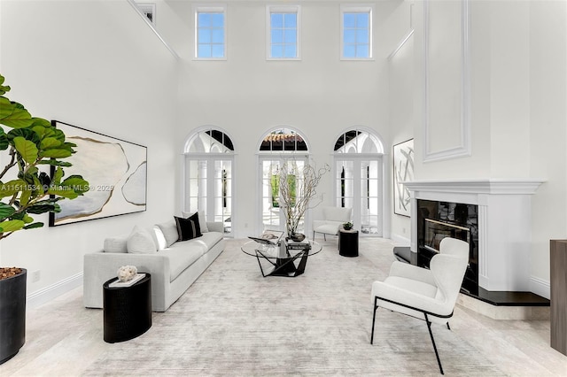 living room featuring a premium fireplace and a high ceiling