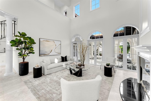 living room featuring decorative columns, french doors, and a towering ceiling