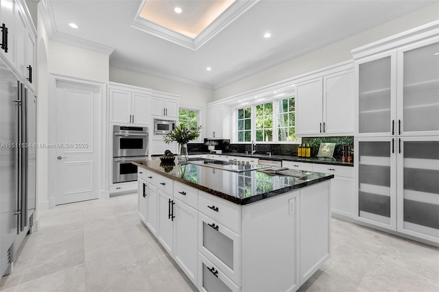 kitchen featuring built in appliances, ornamental molding, tasteful backsplash, a center island, and recessed lighting