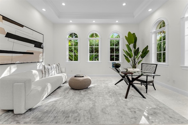 living room featuring plenty of natural light, a raised ceiling, and ornamental molding