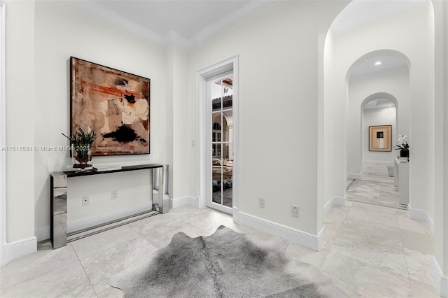 hallway featuring arched walkways, crown molding, and baseboards