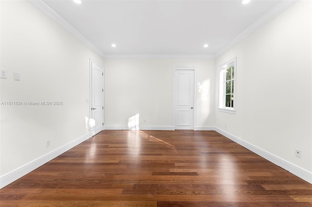 empty room featuring crown molding, wood finished floors, recessed lighting, and baseboards