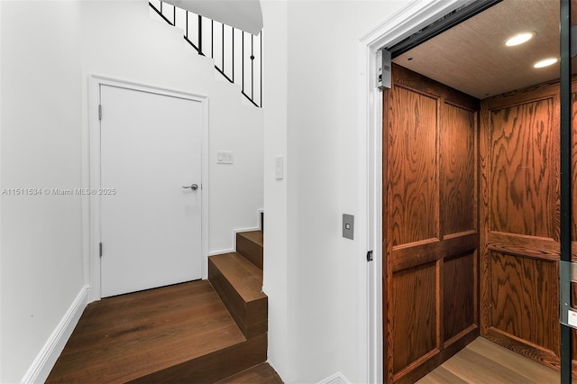 interior space with elevator and hardwood / wood-style flooring