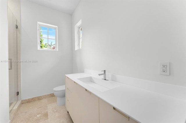 full bath featuring a stall shower, toilet, baseboards, and vanity