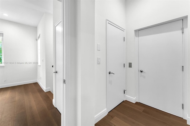 corridor with dark wood-style flooring, baseboards, and recessed lighting
