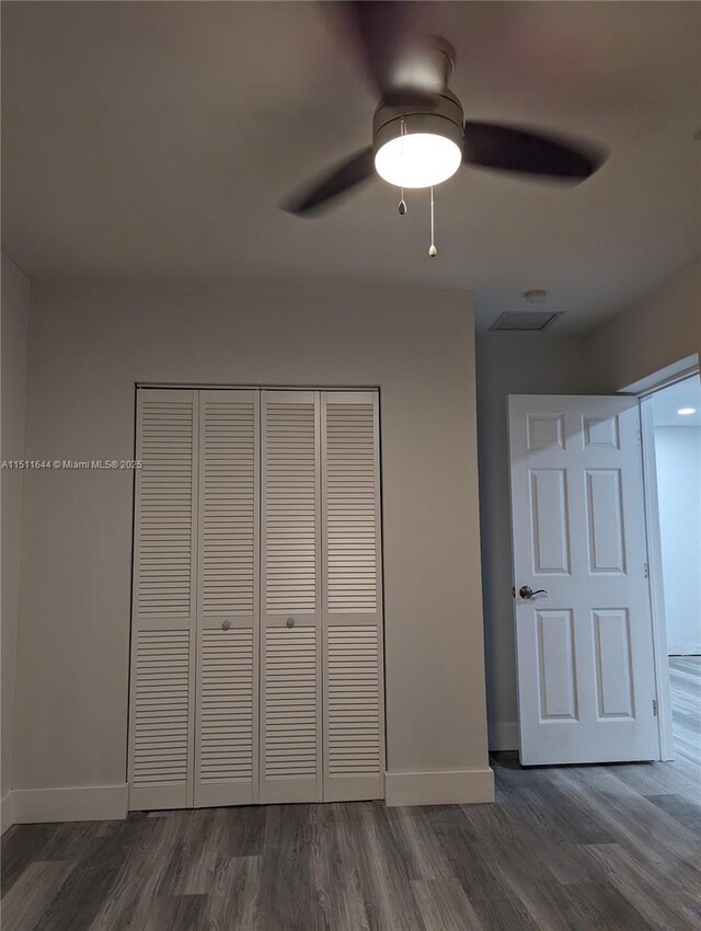 unfurnished bedroom featuring dark hardwood / wood-style flooring and a closet