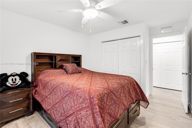 bedroom with light wood-style flooring, a closet, visible vents, and a ceiling fan