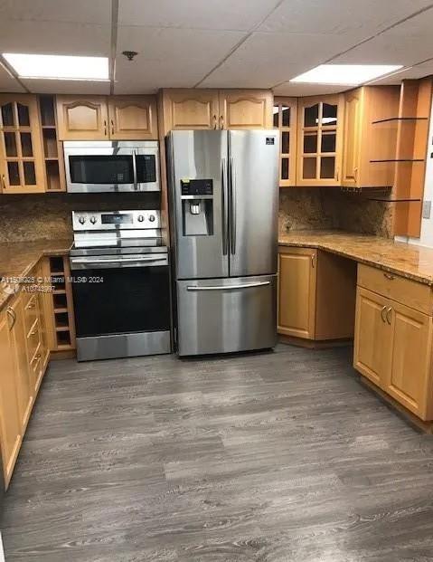 kitchen featuring a paneled ceiling, appliances with stainless steel finishes, tasteful backsplash, and dark hardwood / wood-style flooring