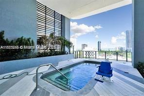 view of swimming pool featuring an in ground hot tub