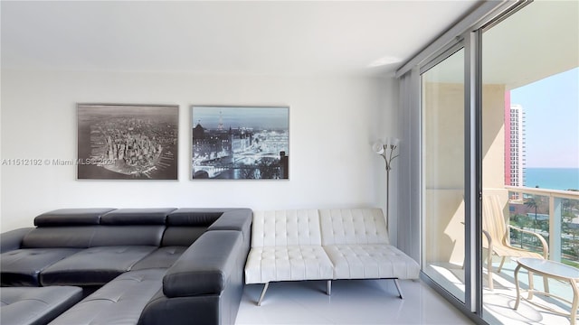 living room with a water view, tile floors, and a wall of windows