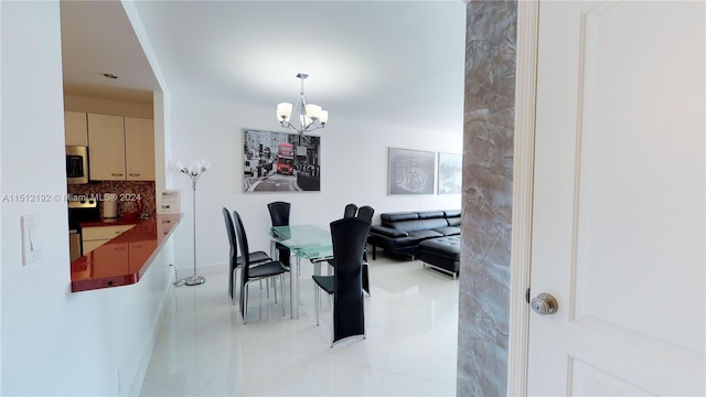 dining area with light tile floors and an inviting chandelier