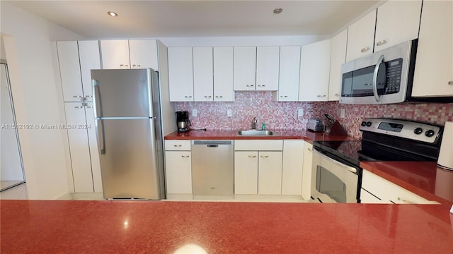 kitchen with backsplash, sink, appliances with stainless steel finishes, and white cabinetry