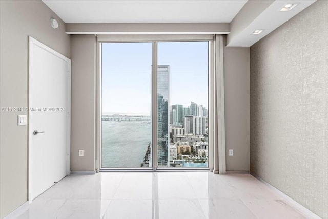 spare room featuring light tile flooring and plenty of natural light