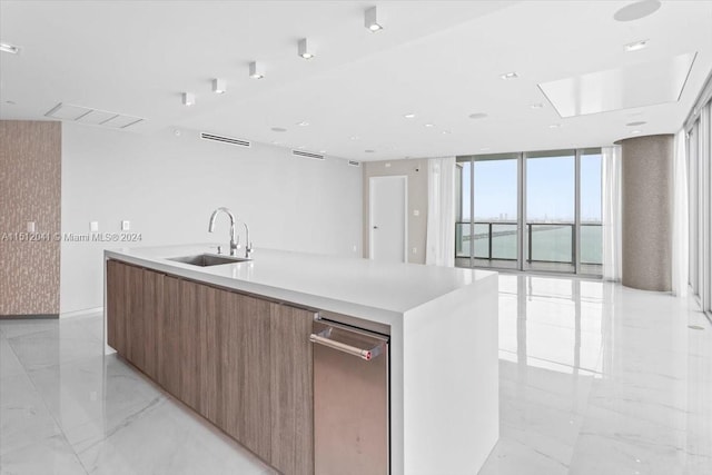 kitchen with light tile floors, expansive windows, a center island with sink, dishwasher, and sink