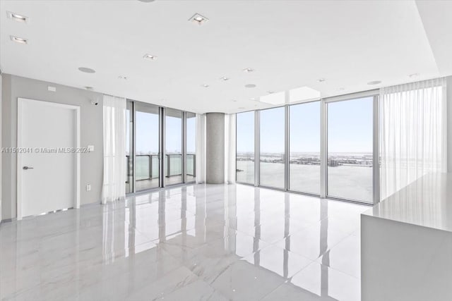 empty room with light tile floors and floor to ceiling windows