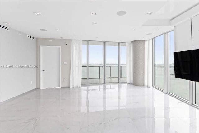 unfurnished room with floor to ceiling windows, plenty of natural light, and light tile flooring