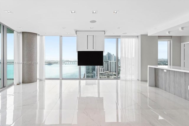 interior space featuring plenty of natural light, light tile floors, and a water view