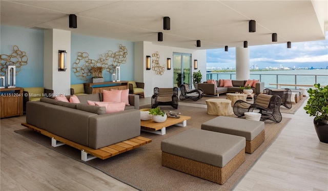 living room featuring a water view and light hardwood / wood-style flooring