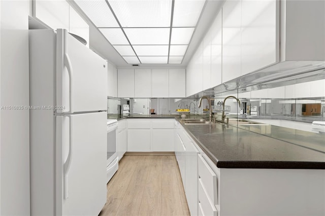 kitchen featuring sink, white cabinets, light hardwood / wood-style flooring, and white appliances