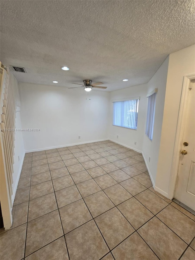 unfurnished room featuring light tile patterned floors, a textured ceiling, and ceiling fan