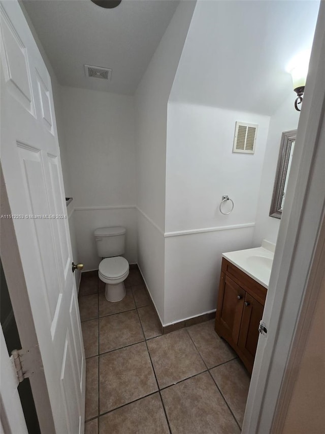 bathroom with tile patterned flooring, vanity, and toilet