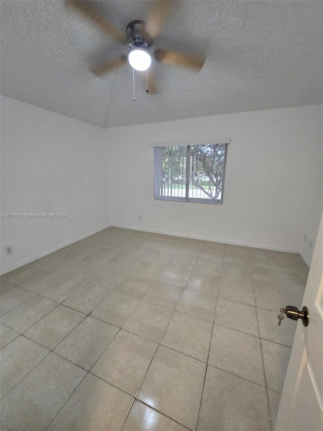 tiled empty room with ceiling fan