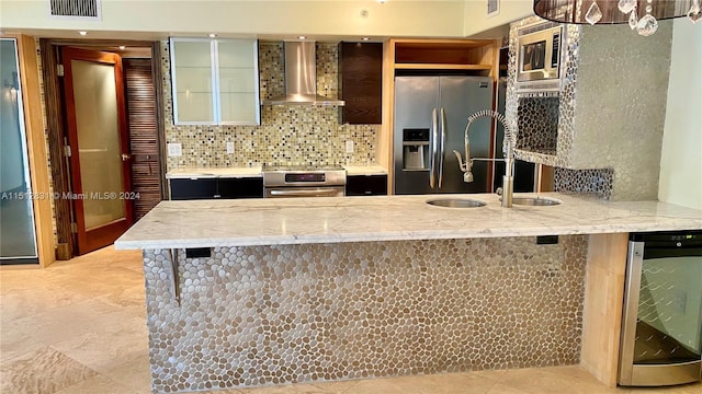 kitchen featuring wall chimney range hood, a kitchen breakfast bar, stainless steel appliances, beverage cooler, and backsplash