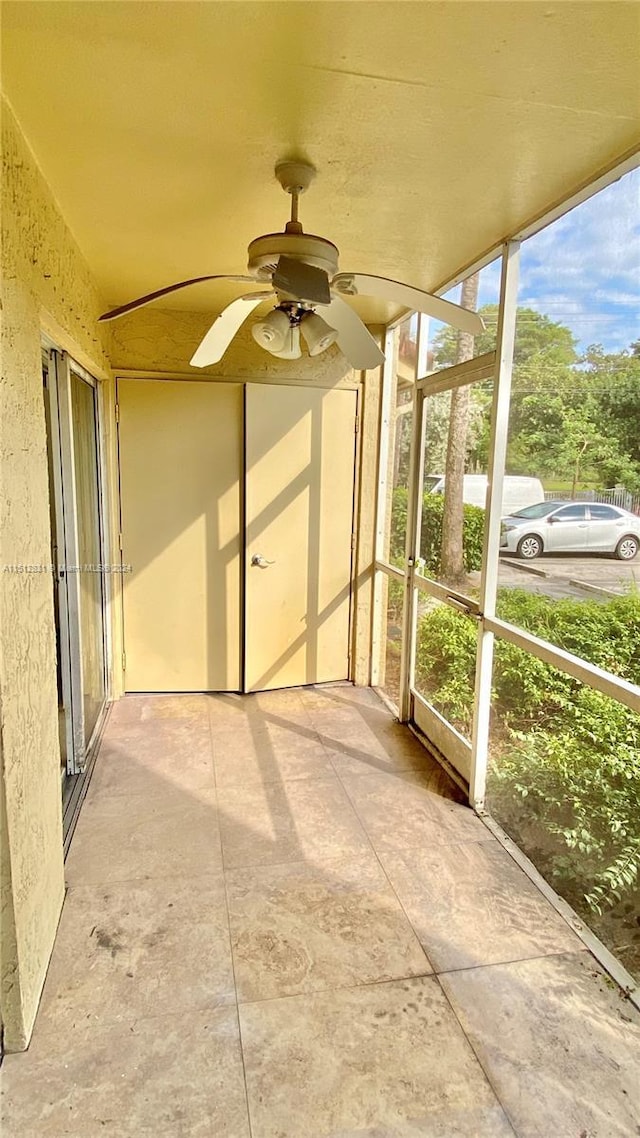 unfurnished sunroom featuring ceiling fan