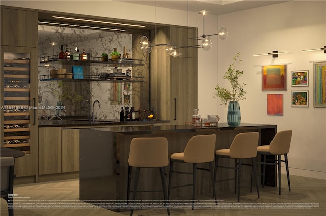 bar featuring sink, light parquet flooring, and decorative light fixtures