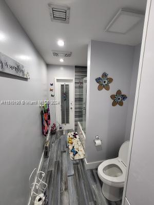 bathroom with toilet and hardwood / wood-style floors